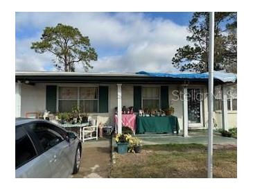 Ranch style home with covered porch and mature trees at 6916 Thrasher Dr, Tampa, FL 33610