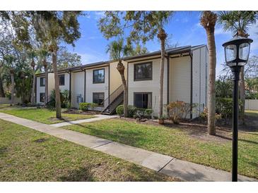 Exterior of a condo building with palm trees, landscaping, and walkway at 314 Moorings Cove Dr, Tarpon Springs, FL 34689
