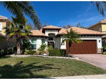 Single-story home with tile roof, large garage, and landscaped lawn at 10880 Cory Lake Dr, Tampa, FL 33647