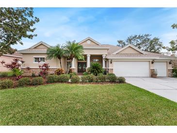 Charming single-story home features manicured lawn, three-car garage, and inviting landscaping at 2902 Big Cypress Way, Wesley Chapel, FL 33544