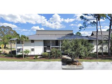 Two-story building exterior, featuring a metal roof and landscaping at 4946 Mill Pond Rd # 3180, Wesley Chapel, FL 33543