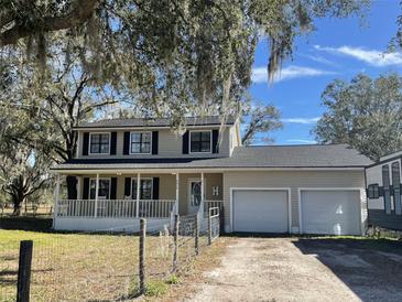 Two-story house with attached garage and a large front porch at 6614 Papa Guy Ln, Plant City, FL 33565