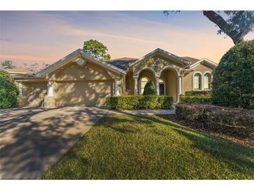 Tan two-story house with a three-car garage and manicured lawn at 125 Falling Water Dr, Brandon, FL 33511
