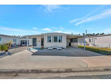 Single-wide mobile home with carport and spacious paved driveway at 322 S Port Royal Ln, Apollo Beach, FL 33572