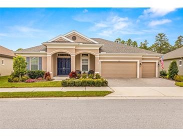 Beautiful one-story home with a three-car garage, landscaped yard, and a welcoming front porch at 4041 Woodland Retreat Blvd, New Port Richey, FL 34655