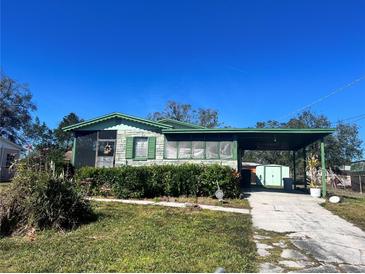 Ranch-style home with carport, screened porch, and well-manicured hedges at 4214 Empire Pl, Tampa, FL 33610