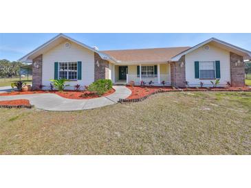 Brick ranch house with green shutters, landscaping, and walkway at 4955 Reece Rd, Plant City, FL 33566