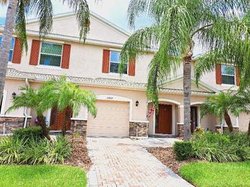 Two-story townhome with attractive landscaping and brick walkway at 27027 Juniper Bay Dr, Wesley Chapel, FL 33544