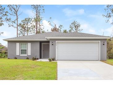 Newly constructed home with gray exterior, two-car garage, and well-manicured lawn at 3843 Laslo Ave, North Port, FL 34287