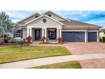 Two-story house with a three-car garage and lush landscaping at 14214 Quintessa Ln, Lithia, FL 33547