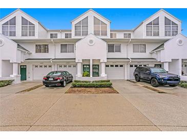 Three-unit townhouse building with two-car garages and landscaping at 14859 Seminole Trl, Seminole, FL 33776