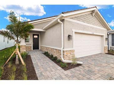 Single-story home with a two-car garage and landscaped walkway at 11498 Boundless Ter, Venice, FL 34293