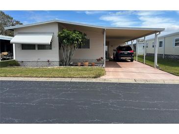 Mobile home with carport and landscaped yard at 12501 Ulmerton Rd # 64, Largo, FL 33774