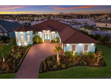 Stunning waterfront home with lush landscaping, brick drive, and serene sunset views overlooking the marina at 1902 4Th E St, Palmetto, FL 34221