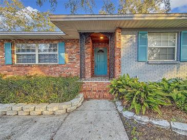 Inviting front entrance with teal door and brick columns at 2446 Belleair Rd, Clearwater, FL 33764