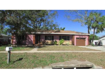 Charming single-story home with a well-maintained lawn, mature trees, and attached one car garage at 3083 55Th N Ave, St Petersburg, FL 33714