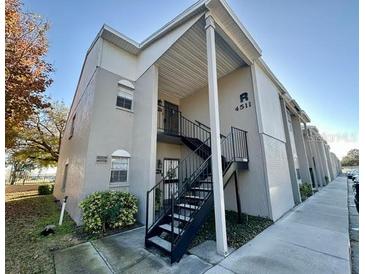 Exterior view of a light-colored building with stairs and a walkway at 4511 S Oak Dr # R12, Tampa, FL 33611