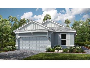 Two-story home with gray siding, two-car garage, and landscaping at 29571 Velletri Ln, Wesley Chapel, FL 33545