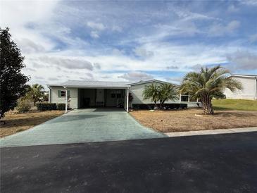 Single-wide manufactured home with carport and palm trees at 37729 Neukom Ave, Zephyrhills, FL 33541