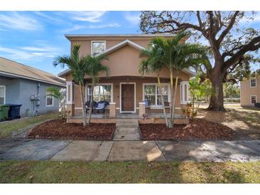 Two-story house with front porch, landscaping, and palm trees at 305 E Hanlon St, Tampa, FL 33604