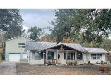 Ranch-style home with metal roof and detached garage at 34799 Evergreen Way, Dade City, FL 33523