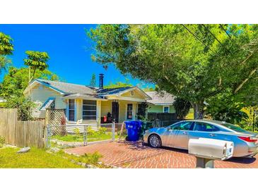 Cute yellow house with brick driveway, and a large tree in front at 616 2Nd Nw Ave, Largo, FL 33770