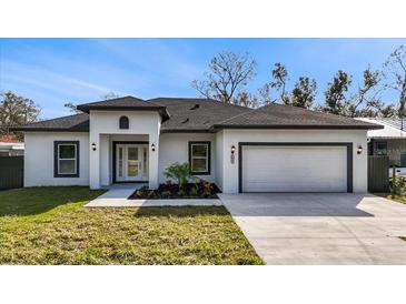 Newly built home with white exterior, dark gray accents, and a two-car garage at 6605 24Th S Ave, Tampa, FL 33619