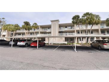 Two-story condo building with covered parking and lush landscaping at 940 Virginia St # 208, Dunedin, FL 34698