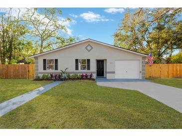 Newly renovated home with a landscaped lawn and modern facade at 12918 Cambridge Ave, Tampa, FL 33624