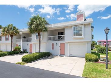 Two-story condo building with pink accents and lush landscaping at 158 Sun Isle Cir, Treasure Island, FL 33706