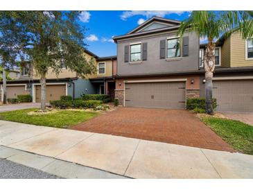 Two-story townhome with two-car garage and landscaped front yard at 17284 Old Tobacco Rd, Lutz, FL 33558