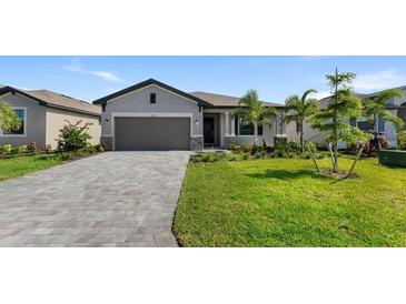 Two-story house with gray siding, paved driveway, and landscaped lawn at 2009 Gardenia Ave, Port Charlotte, FL 33953