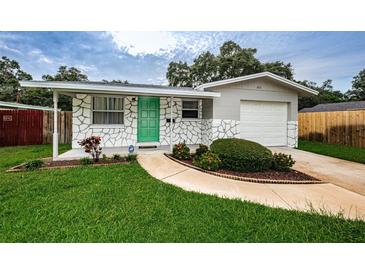 Charming ranch home with green door, landscaped yard, and attached garage at 2511 Quincy S St, St Petersburg, FL 33711