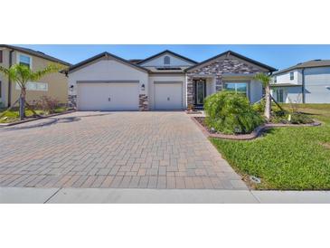 Two-story house with a two-car garage and a brick facade at 3091 King Fern Dr, Wimauma, FL 33598