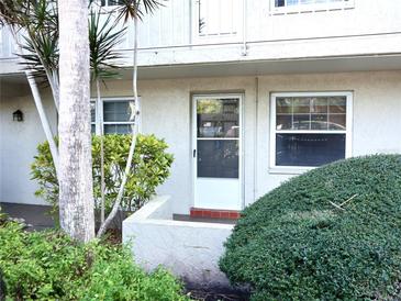 Exterior view of condo building showcasing landscaping and entrance at 946 Virginia St # 102, Dunedin, FL 34698