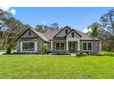 Attractive one-story home with stone accents and a landscaped lawn at 13458 Haflinger Way, Hudson, FL 34667