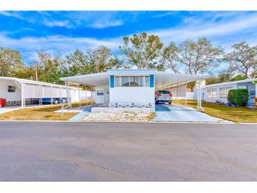 White single-wide mobile home with carport and landscaped yard at 27466 Us Highway 19 N # 78, Clearwater, FL 33761