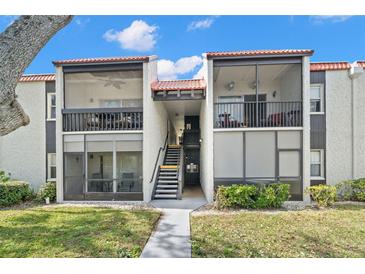 Two-story condo building with screened balconies and lush landscaping at 3245 Beneva Rd # 201, Sarasota, FL 34232