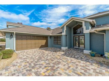 Attractive house exterior featuring a paver driveway and landscaping at 5052 Florentine Ct, Spring Hill, FL 34608
