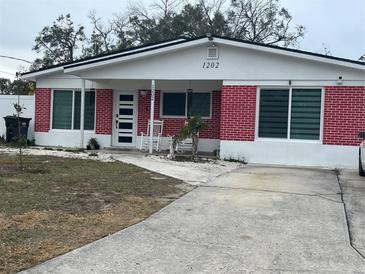Brick house with white accents, rocking chairs on porch at 1202 W Camellia Dr, Brandon, FL 33510