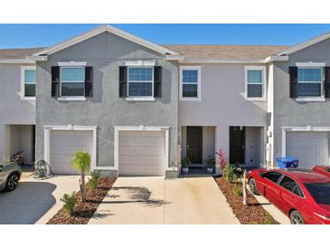 Gray townhome with two-car garage and landscaped front yard at 32241 Turtle Grace Loop, Wesley Chapel, FL 33545