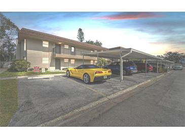 Apartment building with convenient covered parking, car, and tidy landscaping at 9945 47Th N Ave # 206, St Petersburg, FL 33708