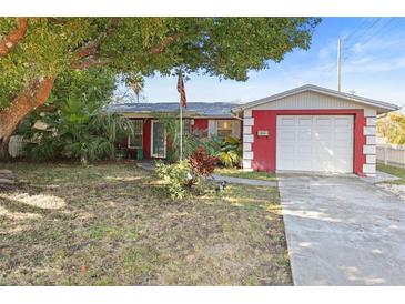 Charming red house with a well-maintained lawn and a spacious driveway at 10941 Oakdale Ave, Port Richey, FL 34668