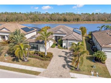 Single-Gathering home with solar panels, paver driveway, and lake view at 17209 Polo Trl, Bradenton, FL 34211