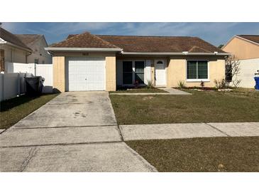 Cute one-story home with a brown roof, white garage door, and well-maintained lawn at 1915 Crown Park Dr, Valrico, FL 33594
