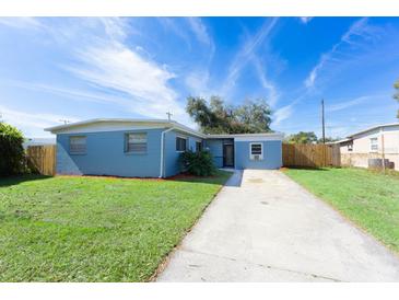 Newly painted light blue home with a spacious yard and driveway at 2009 Windsor Way, Tampa, FL 33619