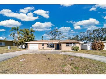 Tan single-story home with a carport and a spacious lawn at 2533 Duncan Dr, Belleair Bluffs, FL 33770