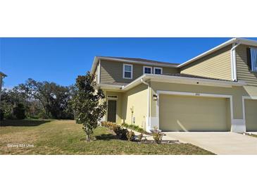 Two-story townhome with attached garage and landscaped front yard at 2933 Jacob Crossing Ln, Holiday, FL 34691