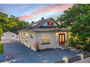 Charming bungalow with a white brick exterior and red front door at 3105 W Spruce St, Tampa, FL 33607