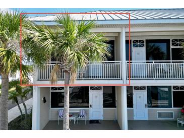 Charming condo exterior featuring white railings and a lush palm tree at 611 Destiny Dr # 410, Ruskin, FL 33570